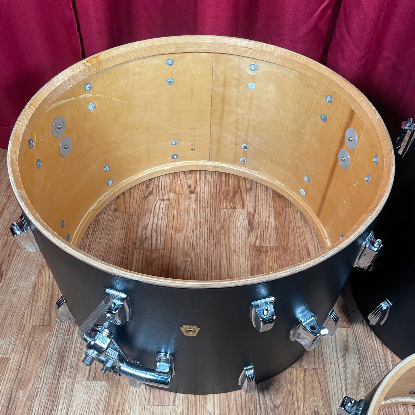 Interior view of the bass drum shell showing the natural maple wood grain and spur mount hardware