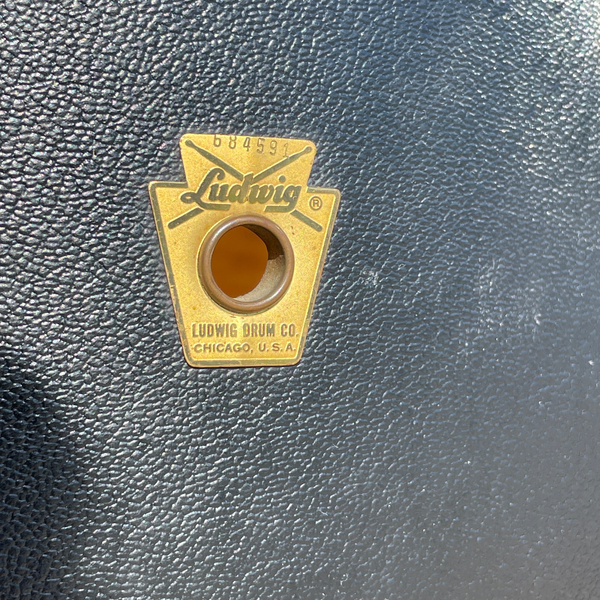 Close-up of the gold Ludwig Keystone badge and mounting grommet on the Black Panther wrap